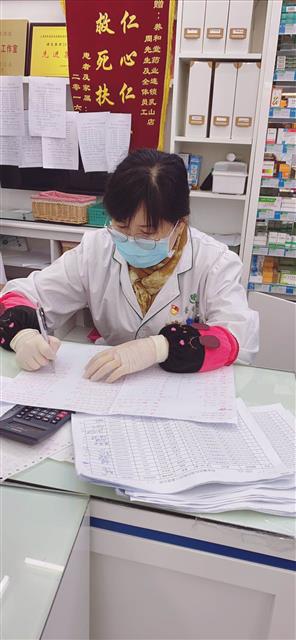 陸萍在統(tǒng)計口罩發(fā)放情況。
