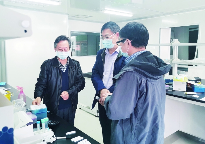 2月23日，廣東省藥監(jiān)局副局長嚴振（中）率隊到廣東和信健康科技有限公司幫助企業(yè)解決新冠病毒檢測試劑注冊申報問題。 王天才 攝