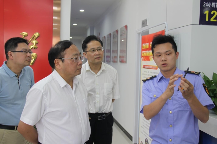 上官新晨（左二）在鷹潭市局東湖分局觀(guān)看基層執(zhí)法人員演示如何運(yùn)用智慧市場(chǎng)監(jiān)管網(wǎng)格化管理平臺(tái)開(kāi)展監(jiān)督檢查工作等情況。