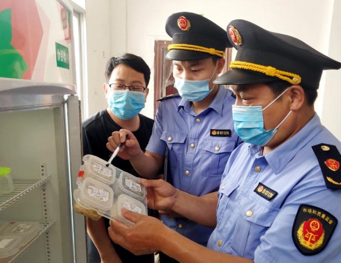 圖為6月8日該局執(zhí)法人員在一鄉(xiāng)鎮(zhèn)學校食堂檢查食品留樣。