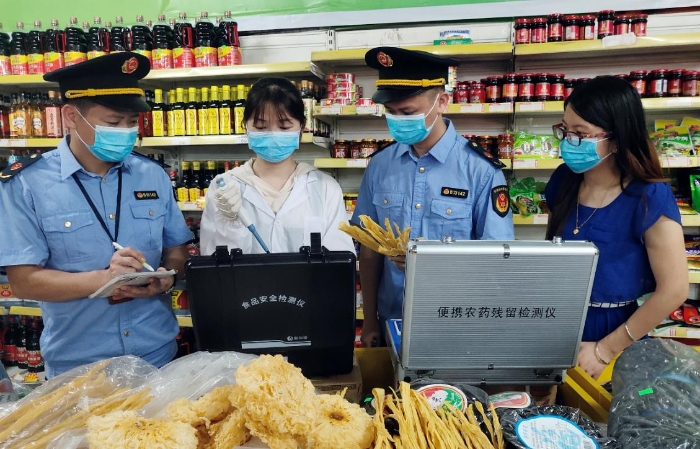 圖為6月21日該局執(zhí)法人員正在一超市檢測食品。