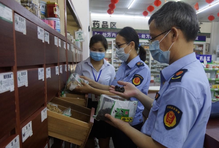 圖為執(zhí)法人員在一家零售藥店檢查中藥飲片。
