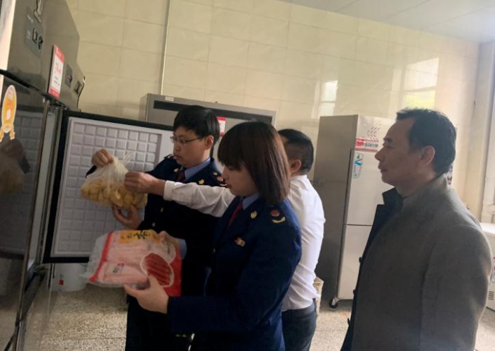 圖為該局執(zhí)法人員檢查學(xué)校食堂食品原料。