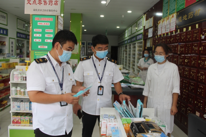 圖為執(zhí)法人員在一家藥店檢查口罩產(chǎn)品質(zhì)量。