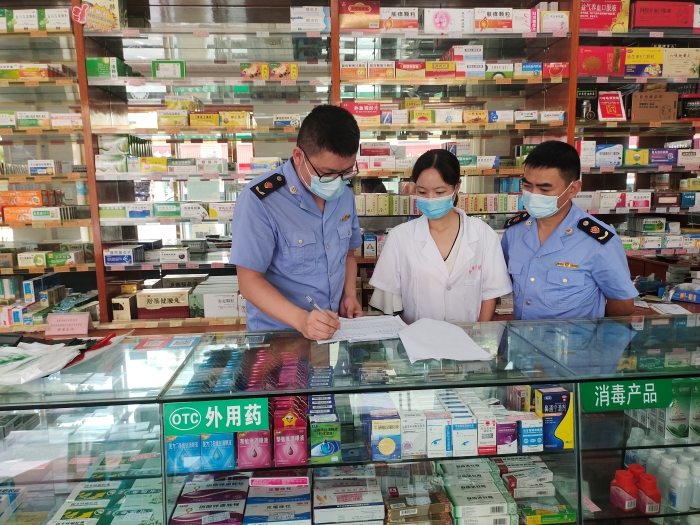 圖為監(jiān)管人員在一家藥店核對(duì)退燒、抗病毒等藥品銷售登記本。