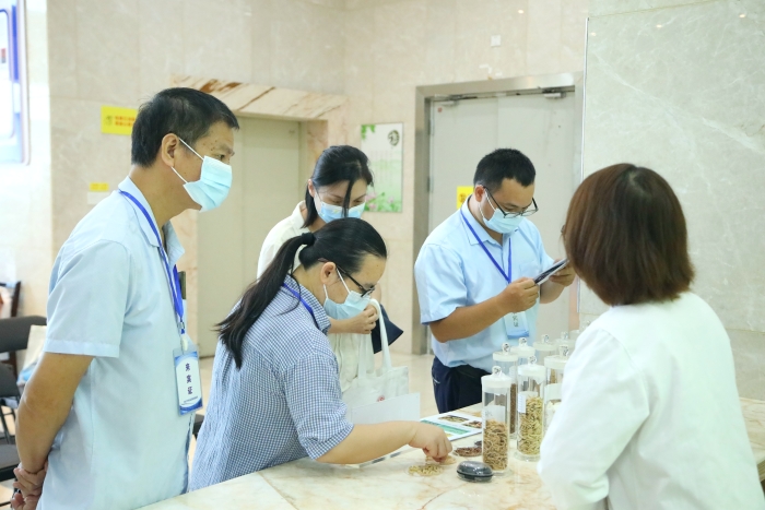 圖為工作人員向市民代表講解中藥材（枸杞、菊花等）真?zhèn)舞b別知識(shí)。