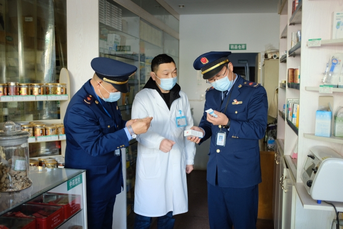 圖為執(zhí)法人員在一家藥店檢查其經(jīng)銷的藥品外包裝上標(biāo)簽是否規(guī)范，并核對(duì)相關(guān)購銷登記臺(tái)賬的信息是否合規(guī)。