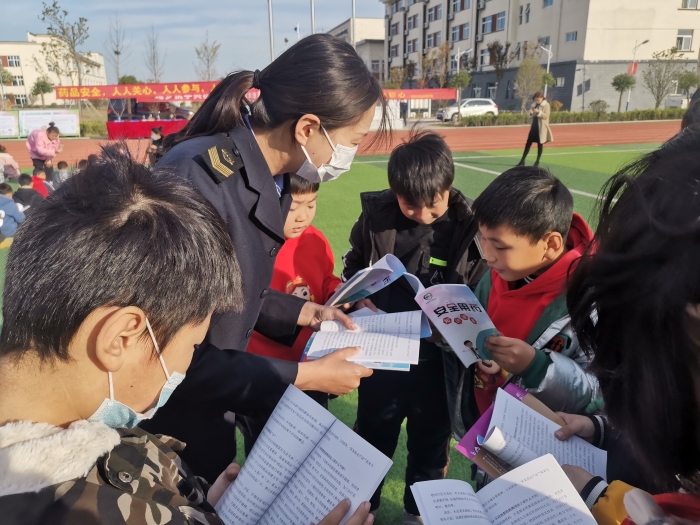 圖為工作人員為小學生講解安全用藥科普知識。