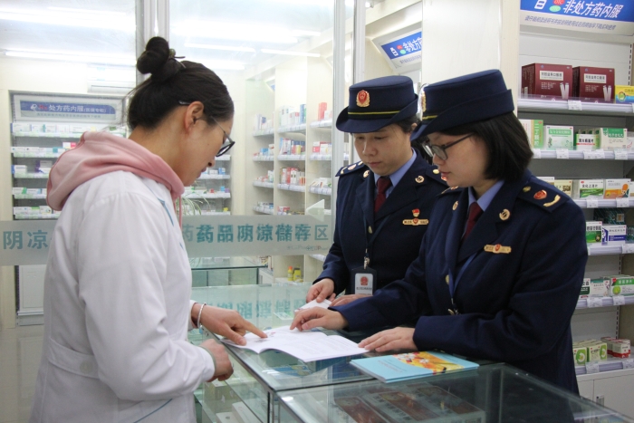 圖為執(zhí)法人員在佰藥之家大藥房發(fā)放安全用藥科普手冊(cè)。