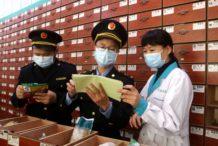 圖為11月24日執(zhí)法人員對一家藥店檢查中藥飲片。