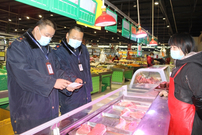 圖為執(zhí)法人員在一家商場檢查肉品相關(guān)手續(xù)。