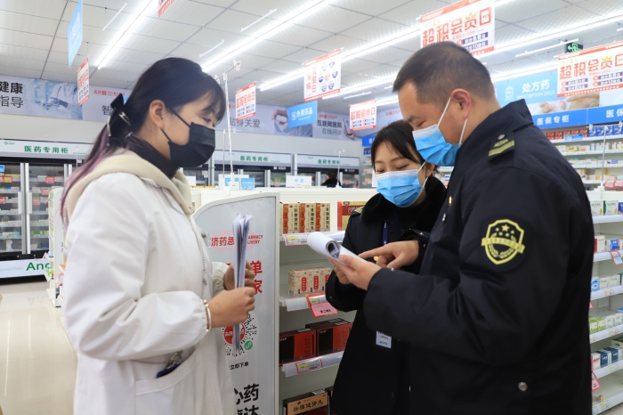 圖為1月11日執(zhí)法人員在一家藥店檢查疫情防控情況。