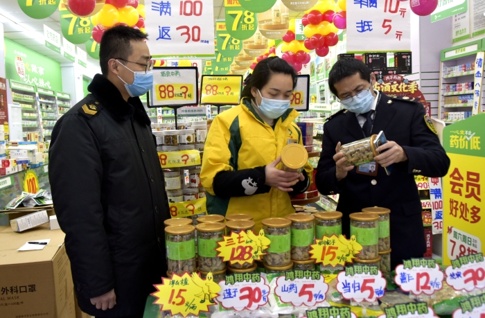 圖為1月14日監(jiān)管人員在一家藥店檢查。