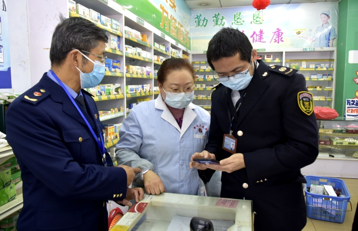 圖為執(zhí)法人員在一家藥店檢查藥品經(jīng)營(yíng)者的智慧監(jiān)管系統(tǒng)的使用情況。