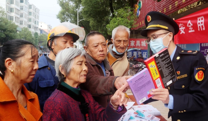 圖為該局工作人員在羅坊鎮(zhèn)集鎮(zhèn)向消費(fèi)者講解如何識別假劣藥品。