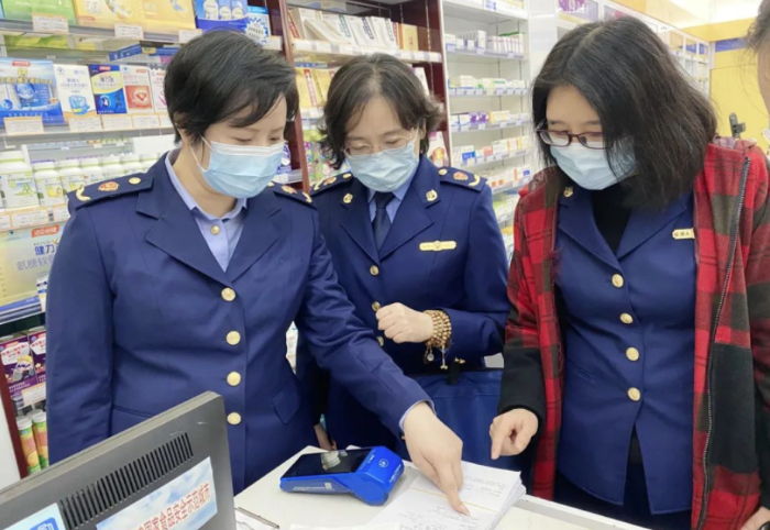 圖為執(zhí)法人員檢查藥品銷售記錄。