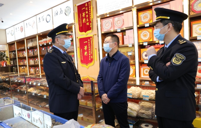 秦繼紅（左一）在中藥材市場(chǎng)聽(tīng)取長(zhǎng)沙市、雨花區(qū)市場(chǎng)監(jiān)管局負(fù)責(zé)人介紹相關(guān)情況。（喻燦華 攝）