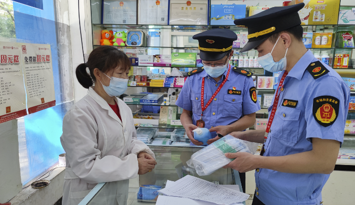 圖為執(zhí)法人員在藥店檢查防疫藥品價(jià)格。