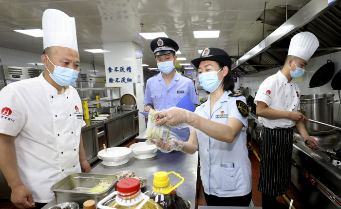圖為淮北市市場監(jiān)管局執(zhí)法人員在一家學(xué)校食堂檢查食品加工環(huán)境。