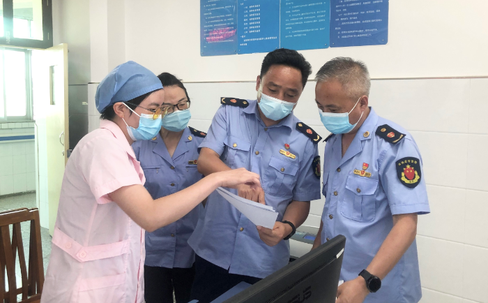 圖為城固縣市場監(jiān)管局執(zhí)法人員查驗疫苗、檢測試劑相關資質(zhì)和冷鏈記錄。