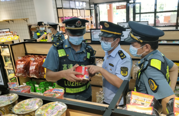 圖為6月27日，于都縣市場監(jiān)管局執(zhí)法人員在于都北服務(wù)區(qū)一家超市內(nèi)檢查是否存在經(jīng)營過期食品問題。