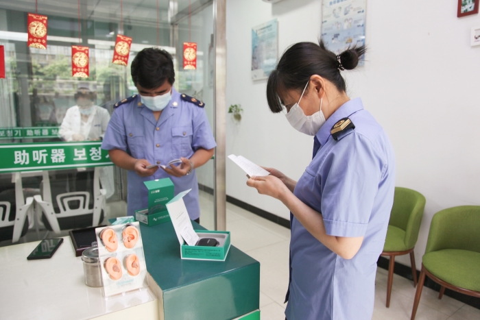 圖為執(zhí)法人員檢查助聽器經(jīng)營企業(yè)產(chǎn)品質(zhì)量安全。
