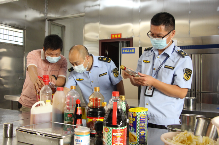 圖為該局執(zhí)法人員在一家餐飲服務單位檢查調(diào)味料的保質(zhì)期。