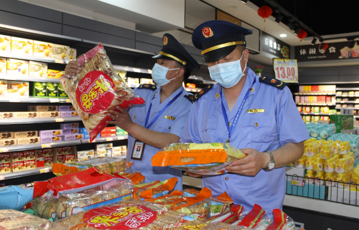 圖為該局執(zhí)法人員在一家農(nóng)村超市查看食品包裝。