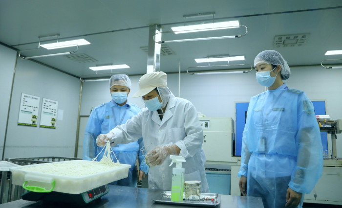 圖為該局工作人員在廣西三品王米粉生產(chǎn)基地對鮮濕米粉開展出廠檢驗(yàn)取樣。