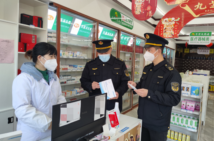 圖為該局執(zhí)法人員在一家零售藥店檢查新冠病毒抗原檢測試劑質(zhì)量。