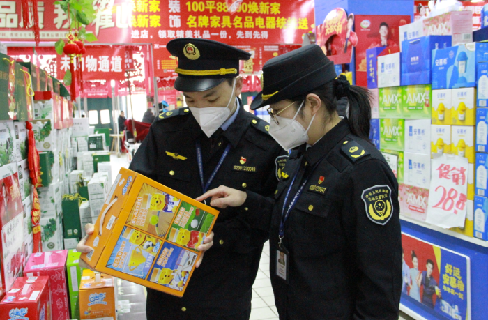 圖為該局執(zhí)法人員在一家商場檢查在售食品是否超過保質(zhì)期。
