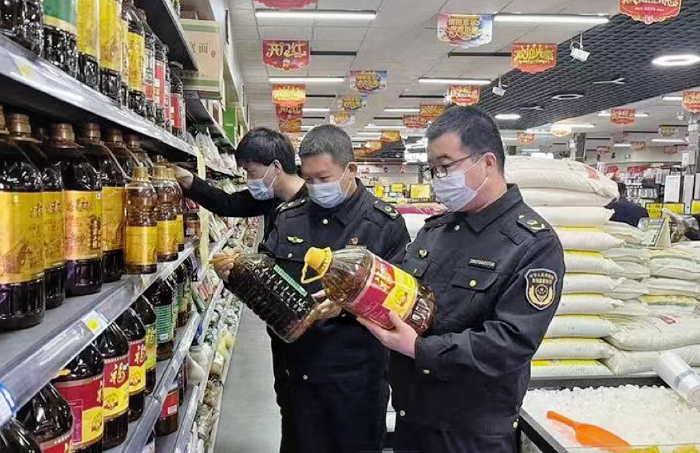 圖為該局執(zhí)法人員在一家超市檢查食用植物油包裝標簽標識。