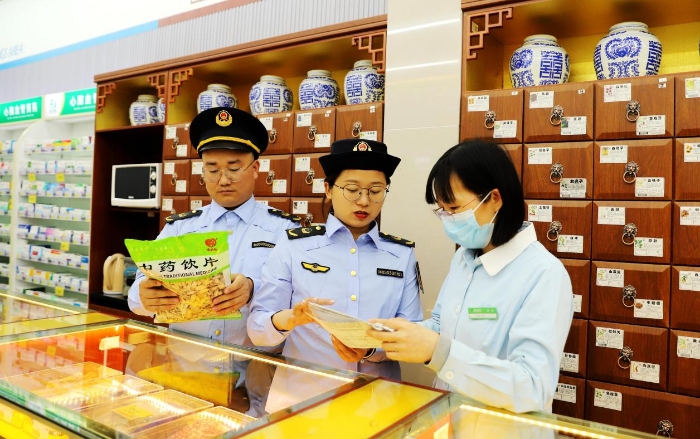 圖為4月25日，執(zhí)法人員在對一家零售藥店的中藥飲片進(jìn)行檢查。