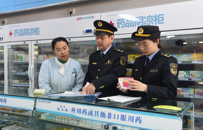 圖為執(zhí)法人員在一家藥品經(jīng)營企業(yè)檢查藥品采購和陰涼藥品儲存記錄情況。