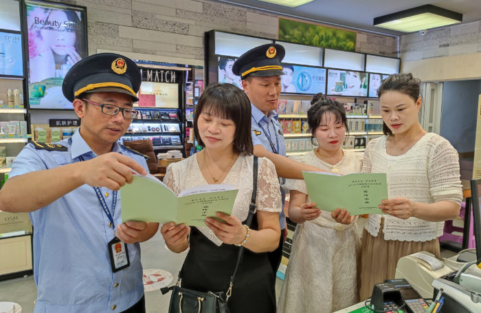 圖為該局執(zhí)法人員在一家化妝品專賣店向經(jīng)營者及消費者講解化妝品安全知識。