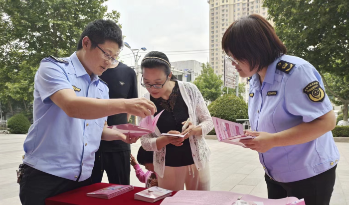 圖為該局工作人員向群眾發(fā)放化妝品科普宣傳資料。