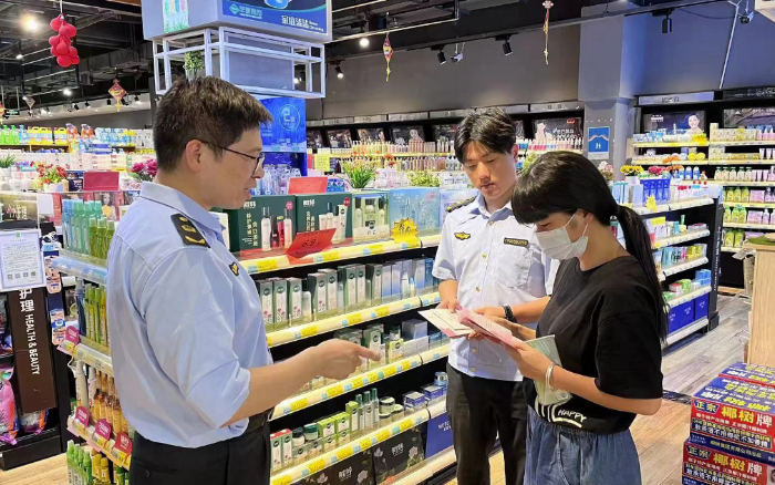 圖為該局工作人員在商場(chǎng)向群眾宣傳化妝品安全知識(shí)。