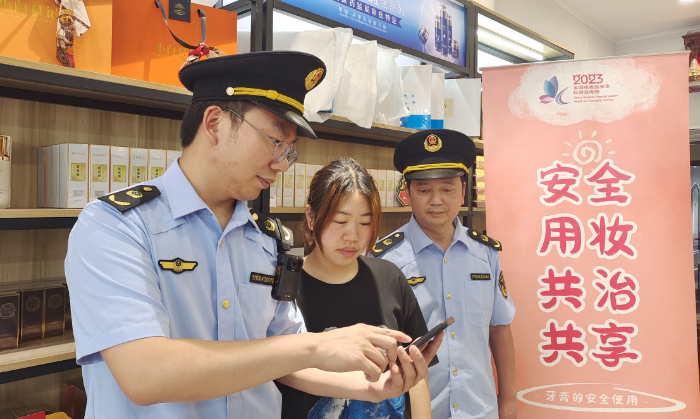 圖為執(zhí)法人員指導(dǎo)經(jīng)營(yíng)戶使用“數(shù)字辨妝”一體化監(jiān)管平臺(tái)的云管理模塊。