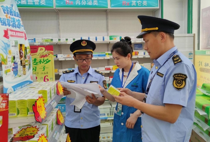 圖為6月5日執(zhí)法人員在一家藥店檢查防暑藥品質(zhì)量情況。