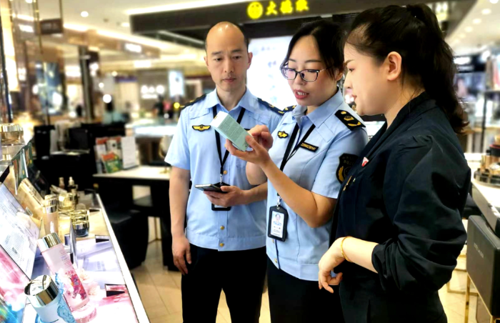圖為該局執(zhí)法人員在一家商場檢查化妝品標識情況。