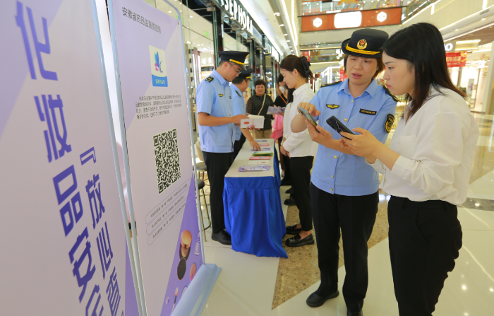 圖為9月13日，該局執(zhí)法人員正在指導化妝品經(jīng)營者安裝使用該APP。