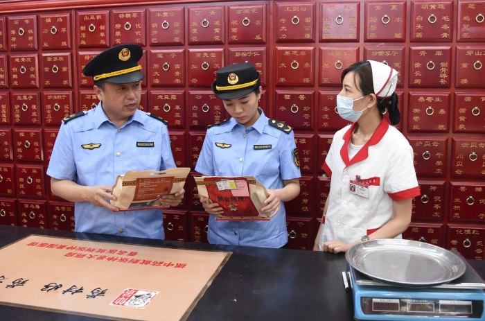 圖為執(zhí)法人員正在一家藥品經(jīng)營企業(yè)抽檢中藥飲片。