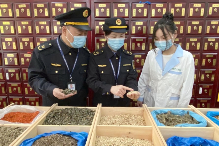圖為執(zhí)法人員檢查中藥飲片。