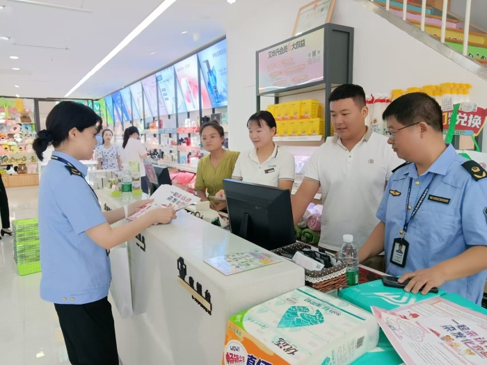 圖為執(zhí)法人員在一家商場發(fā)放宣傳材料。