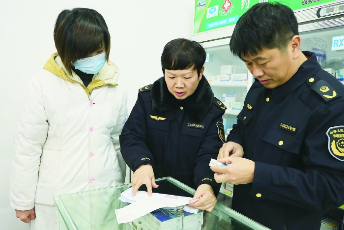 圖②為2024年1月30日，在藥品檢查專項行動中，衡陽市市場監(jiān)管局工作人員正在零售藥店查看臺賬資料。